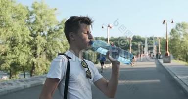少年男孩喝瓶水，夏日炎炎，河桥背景
